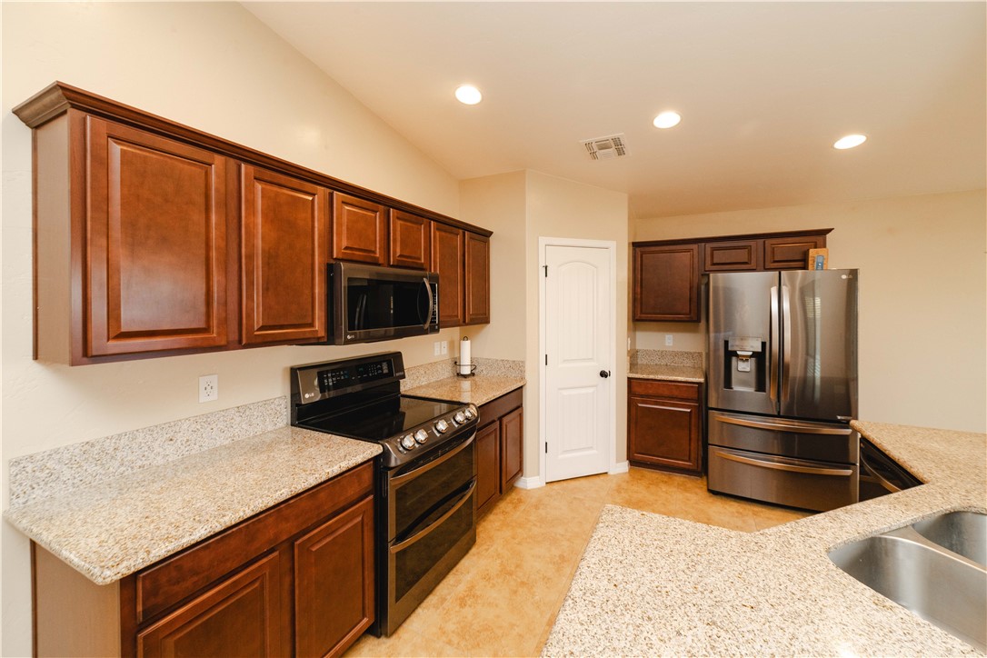 3379 Motherload Road Kingman, AZ 86401 - Photo 17 of 67 Kitchen featuring stainless steel appliances, light stone counters, recessed lighting, and dark brown cabinetry