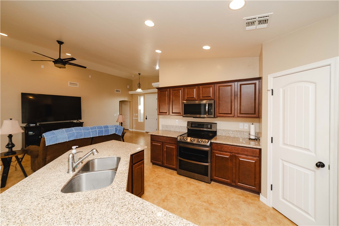 3379 Motherload Road Kingman, AZ 86401 - Photo 67 of 67 Kitchen featuring stainless steel appliances, a ceiling fan, light stone counters, open floor plan, and recessed lighting