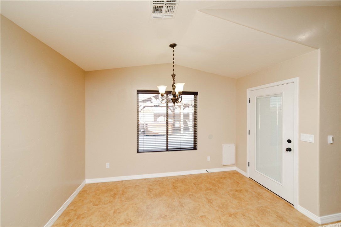3379 Motherload Road Kingman, AZ 86401 - Photo 18 of 67 Empty room featuring vaulted ceiling and a chandelier