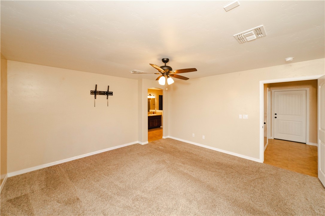 3379 Motherload Road Kingman, AZ 86401 - Photo 22 of 67 Empty room featuring light carpet, ceiling fan, and arched walkways