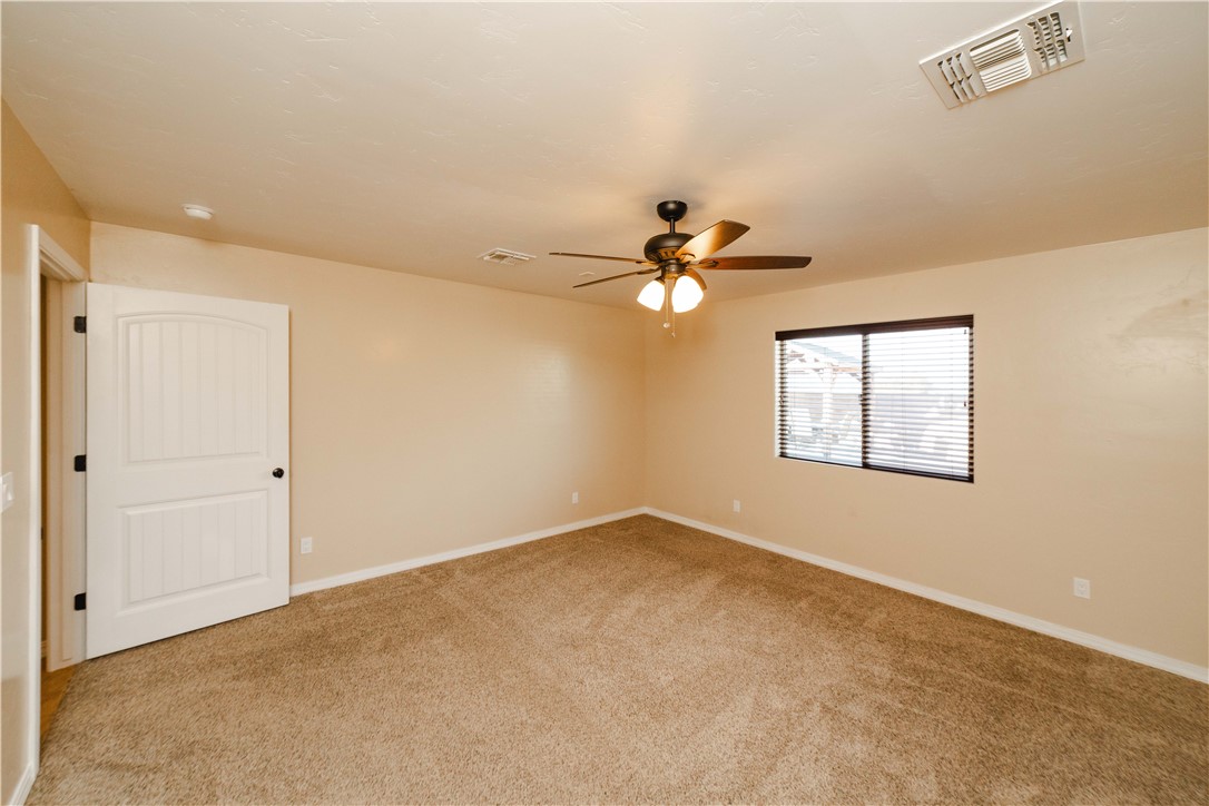 3379 Motherload Road Kingman, AZ 86401 - Photo 24 of 67 Empty room featuring light colored carpet and a ceiling fan
