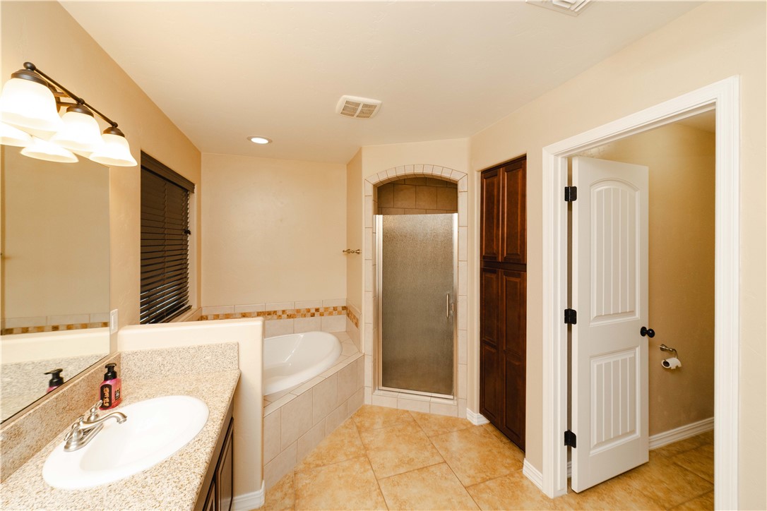 3379 Motherload Road Kingman, AZ 86401 - Photo 26 of 67 Full bath with vanity, a stall shower, a bath, light tile patterned floors, and recessed lighting