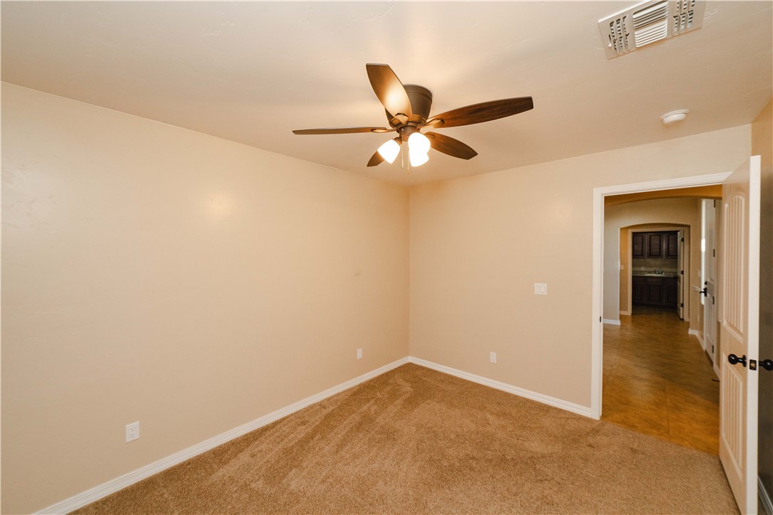 3379 Motherload Road Kingman, AZ 86401 - Photo 33 of 67 Spare room featuring ceiling fan, light carpet, and arched walkways