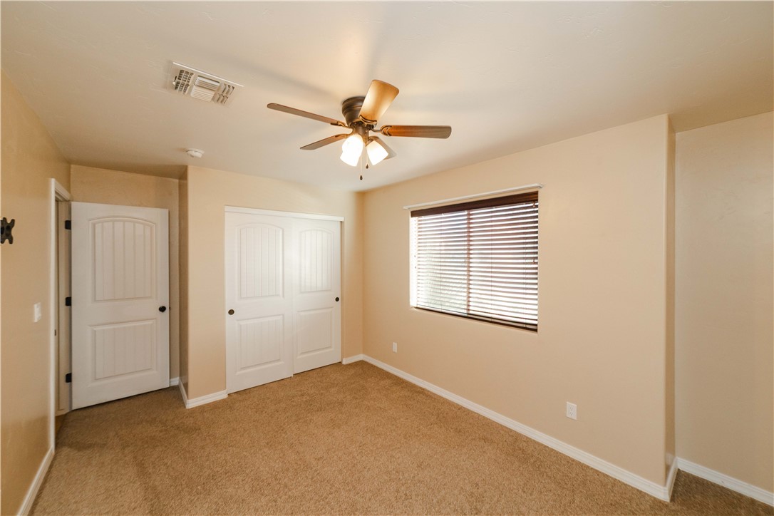 3379 Motherload Road Kingman, AZ 86401 - Photo 38 of 67 Unfurnished bedroom featuring light carpet, a closet, and ceiling fan