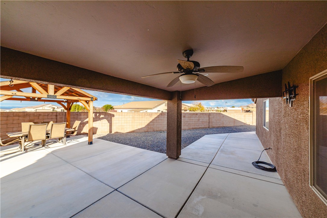 3379 Motherload Road Kingman, AZ 86401 - Photo 62 of 67 Fenced backyard with a patio area, a ceiling fan, and outdoor dining space