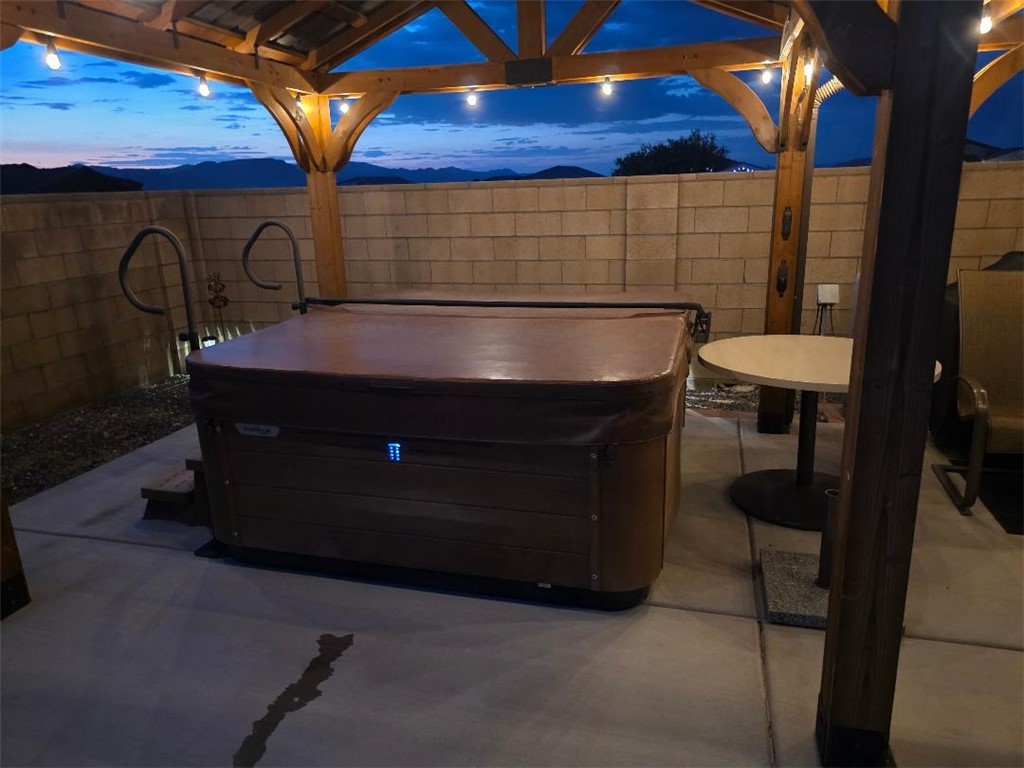 3379 Motherload Road Kingman, AZ 86401 - Photo 63 of 67 Patio terrace at dusk featuring a hot tub, a patio area, and a fenced backyard