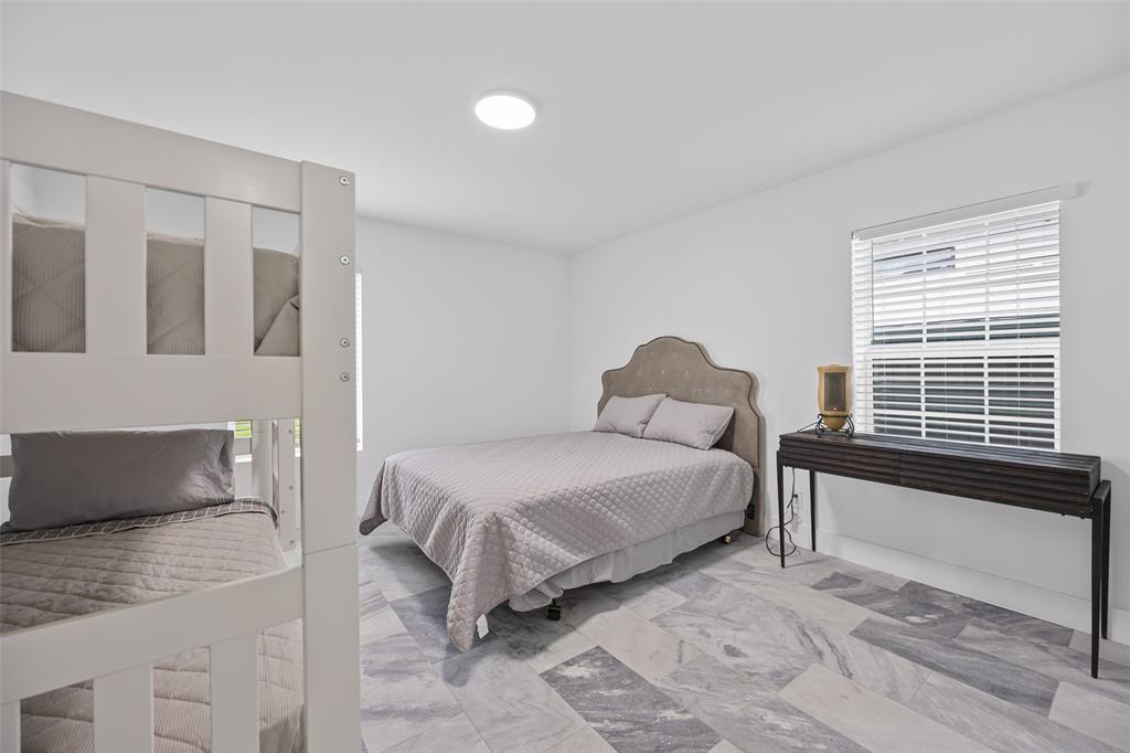 4419 Sexton Lane Dallas, TX 75229 - Photo 16 of 24 Bedroom with multiple windows and marble look tiles