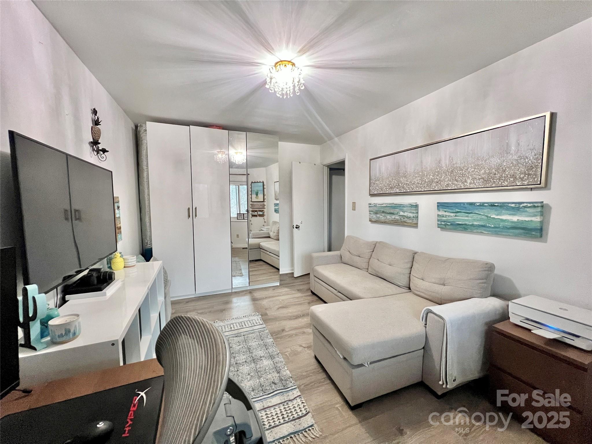 9009 Cebu Court Fort Mill, SC 29708 - Photo 20 of 35 a living room with furniture a chandelier and a flat screen tv