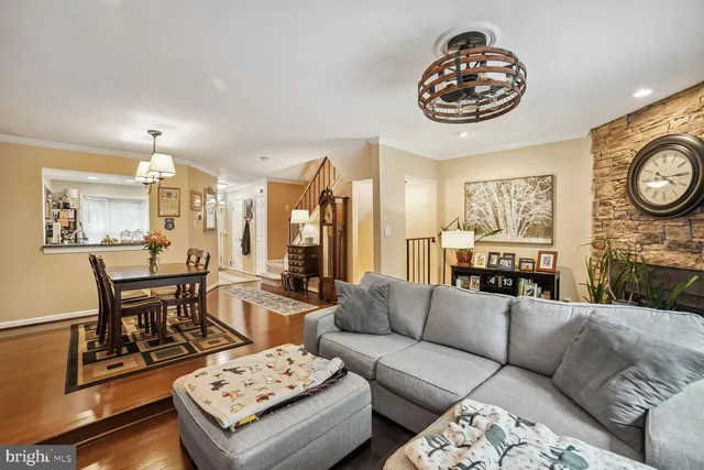a living room with furniture a rug kitchen view and a table