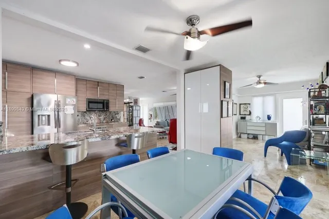 a living room with stainless steel appliances kitchen island granite countertop furniture and a view of kitchen