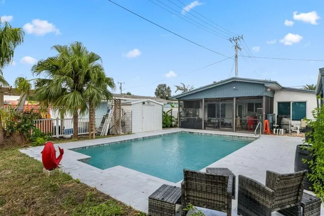 a view of a house with backyard and sitting area