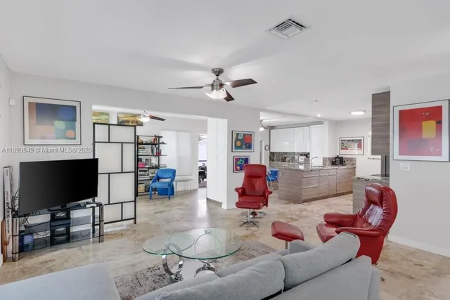 a living room with furniture kitchen view and a flat screen tv