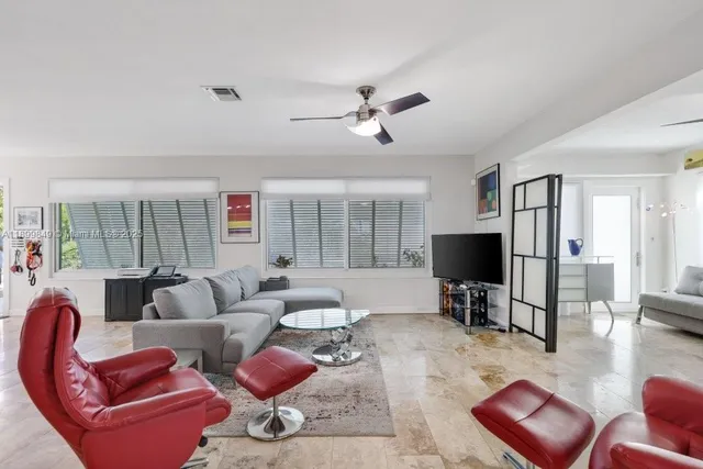 a living room with furniture a flat screen tv and a large window
