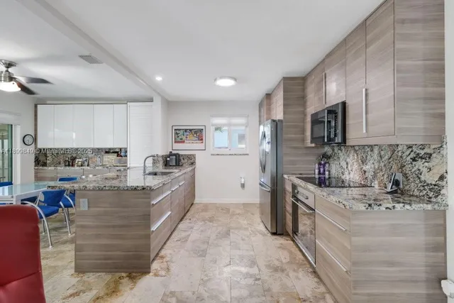 a large kitchen with stainless steel appliances cabinets a sink and a counter top space