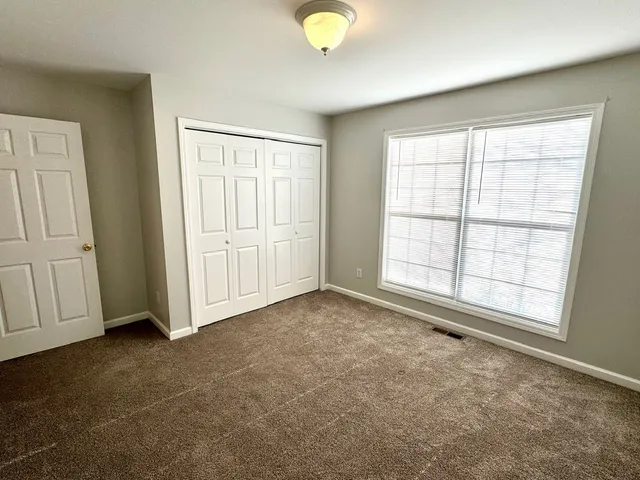 an empty room with windows and closet