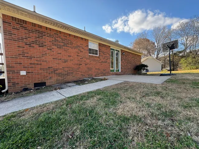 a view of a backyard with plants and a garage