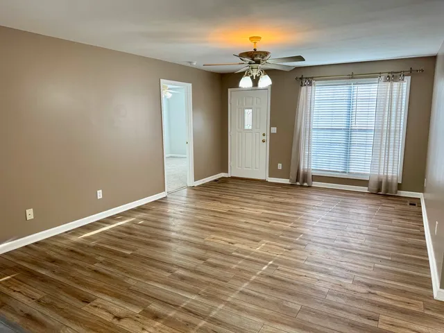 wooden floor in an empty room with a window