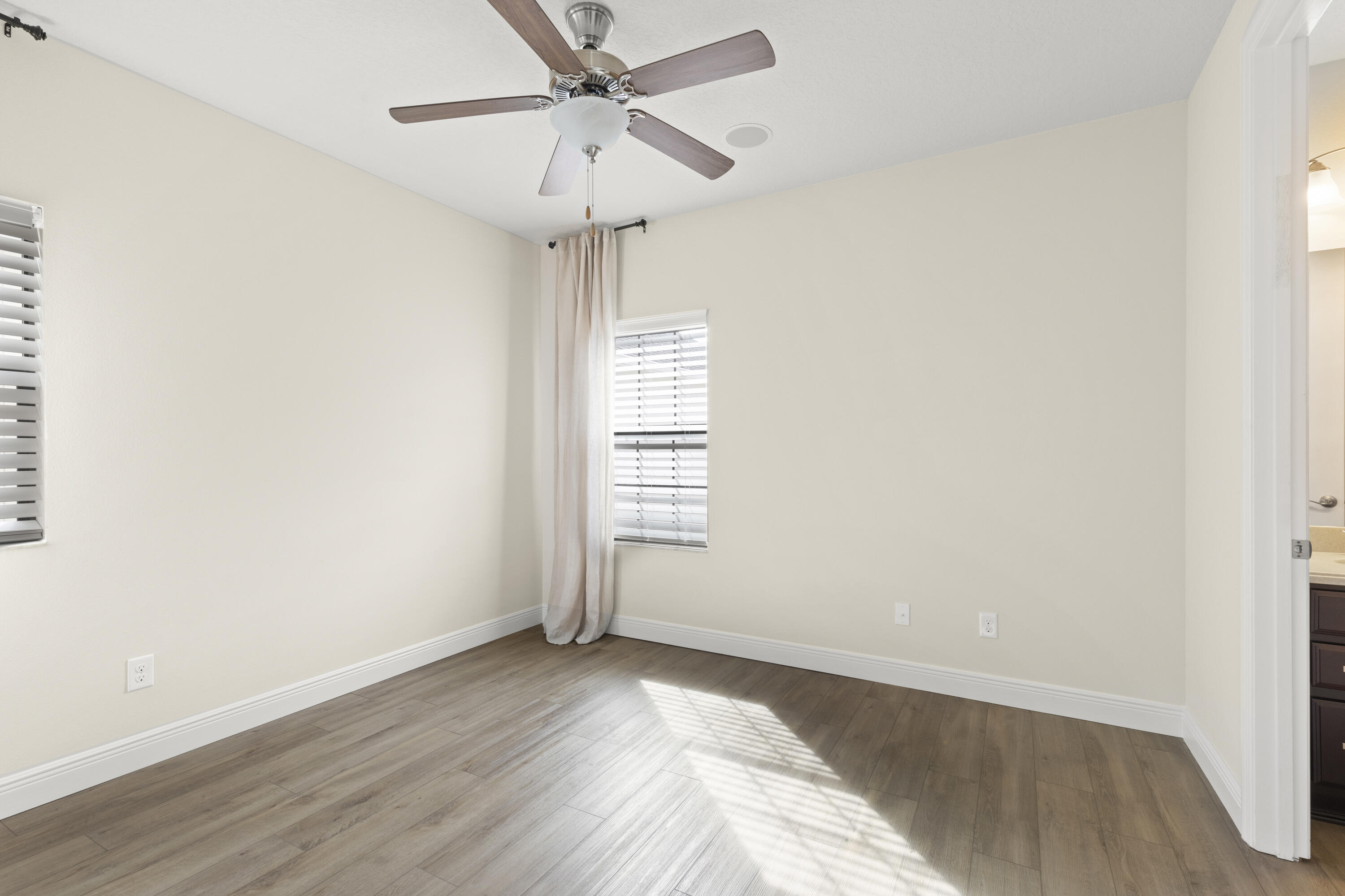 7065 Primavera Lane Melbourne, FL 32940 - Photo 18 of 40 an empty room with wooden floor and windows