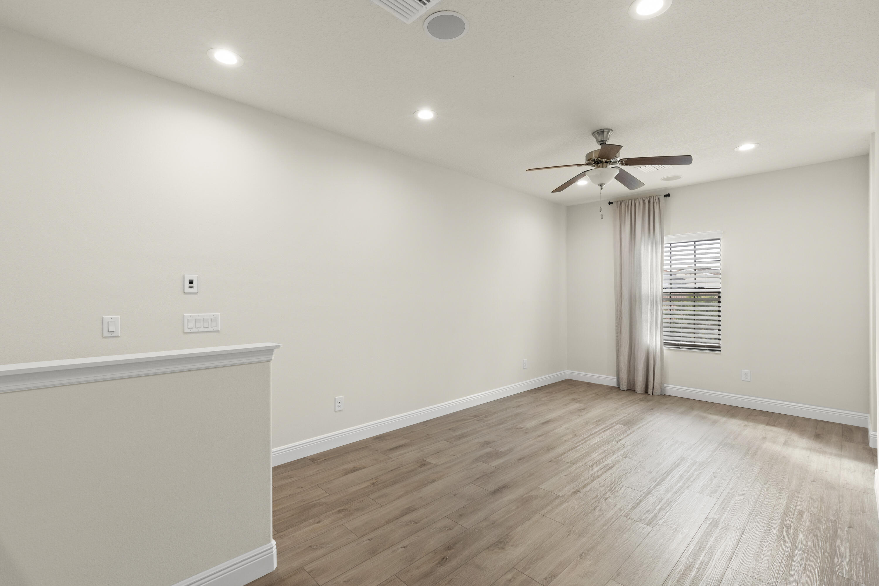 7065 Primavera Lane Melbourne, FL 32940 - Photo 22 of 40 wooden floor in an empty room with a window