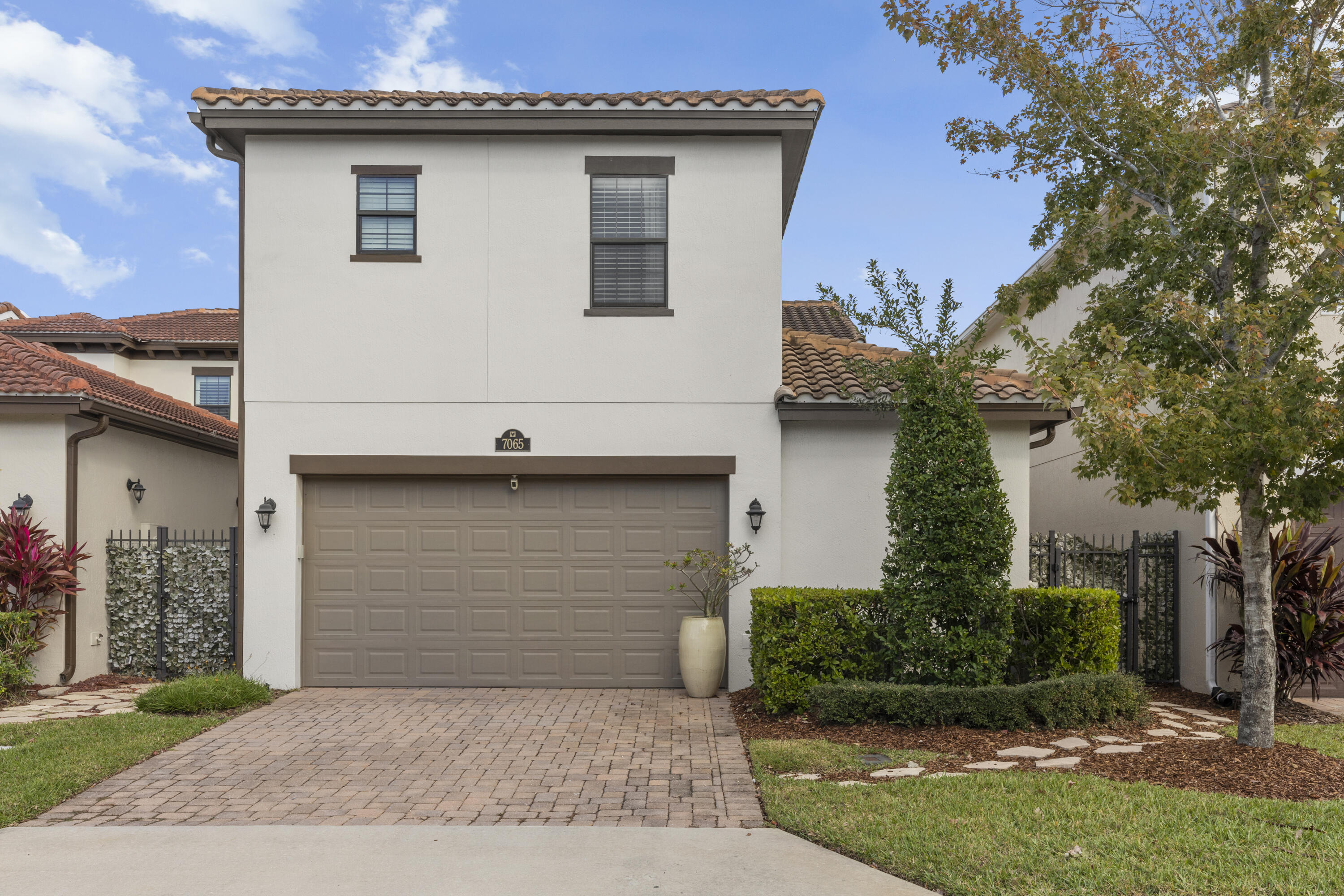 7065 Primavera Lane Melbourne, FL 32940 - Photo 3 of 40 a front view of a house with a garden