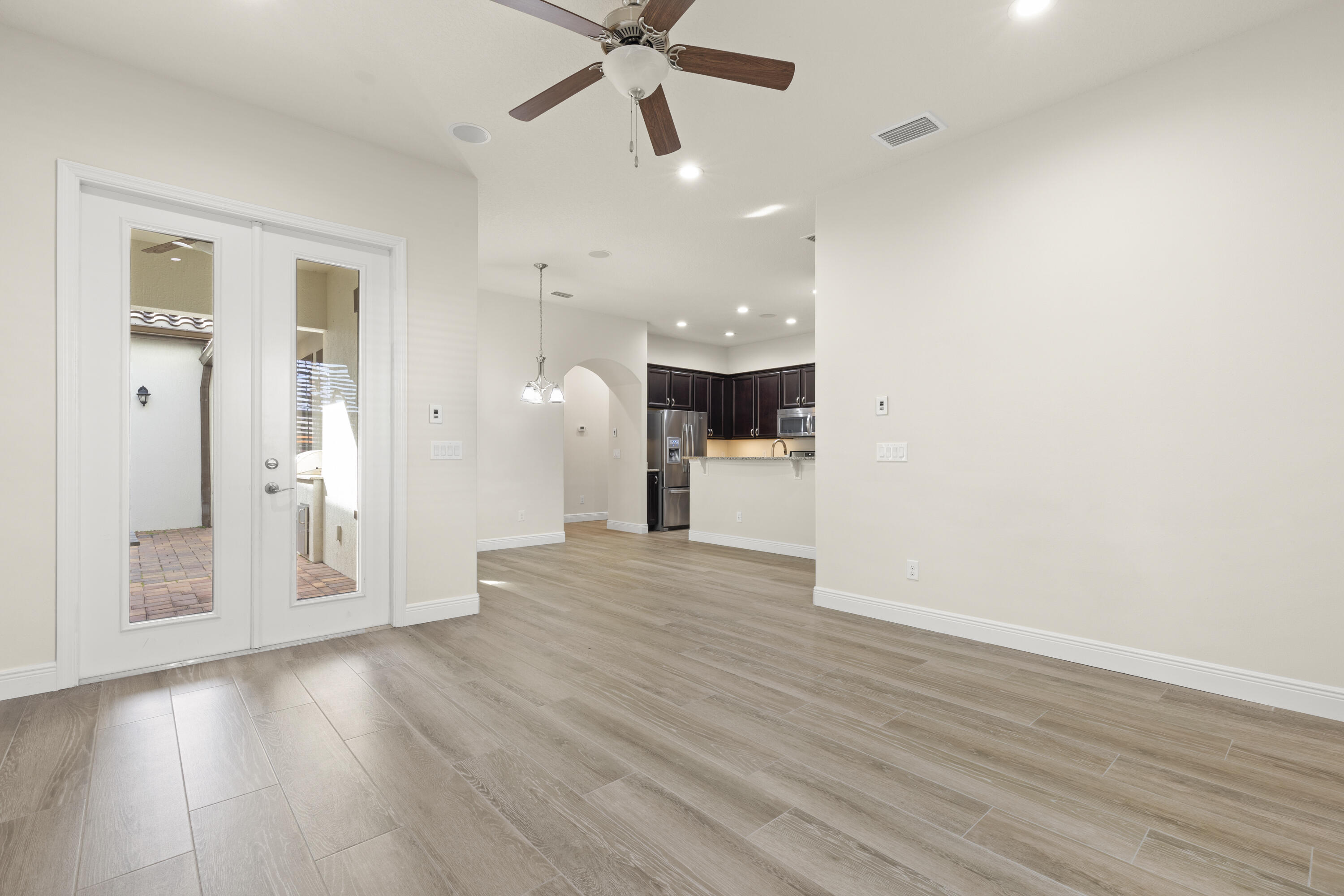 7065 Primavera Lane Melbourne, FL 32940 - Photo 6 of 40 wooden floor in an empty room with a window