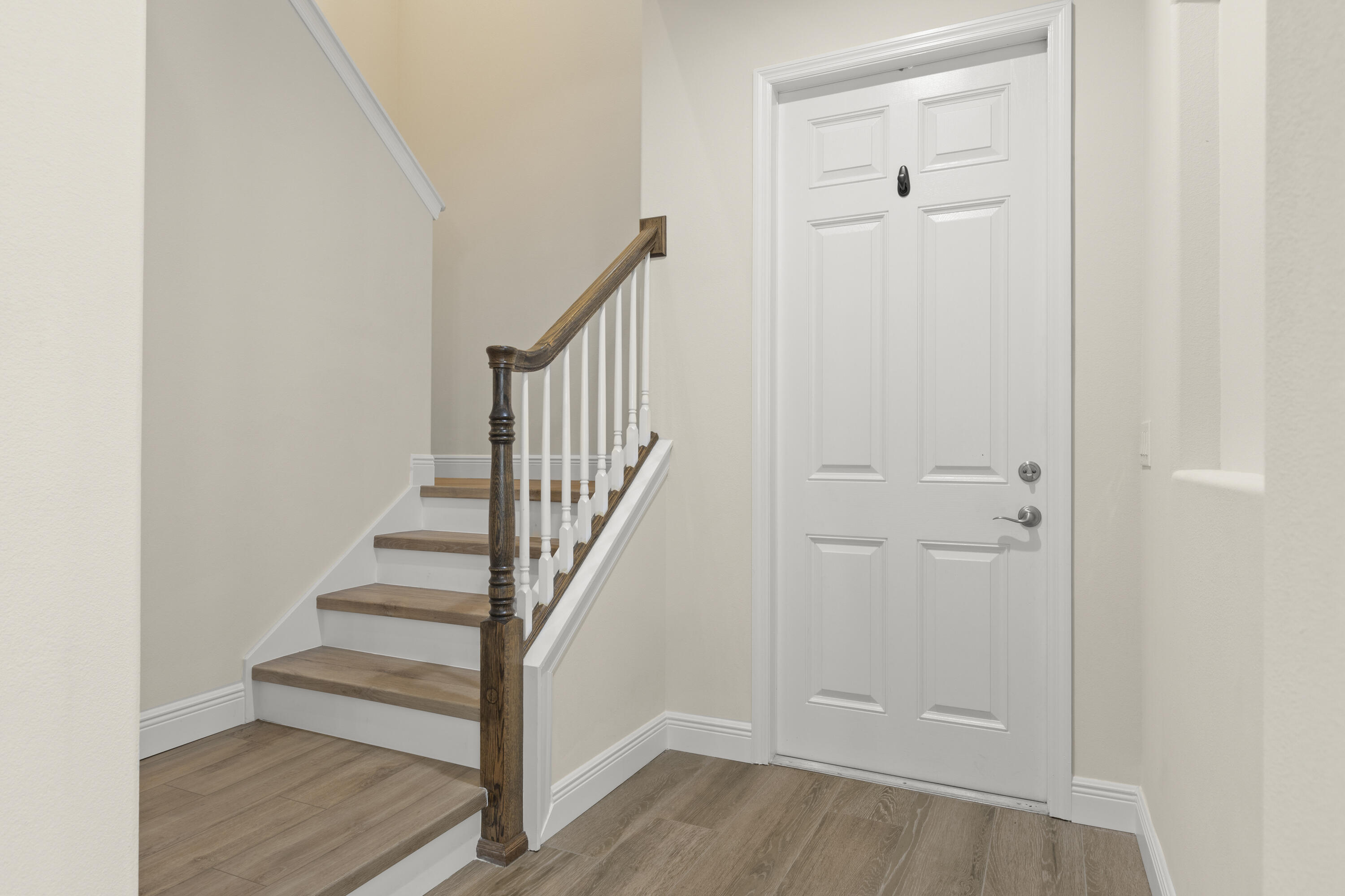 7065 Primavera Lane Melbourne, FL 32940 - Photo 7 of 40 a view of a hallway with wooden floor and staircase