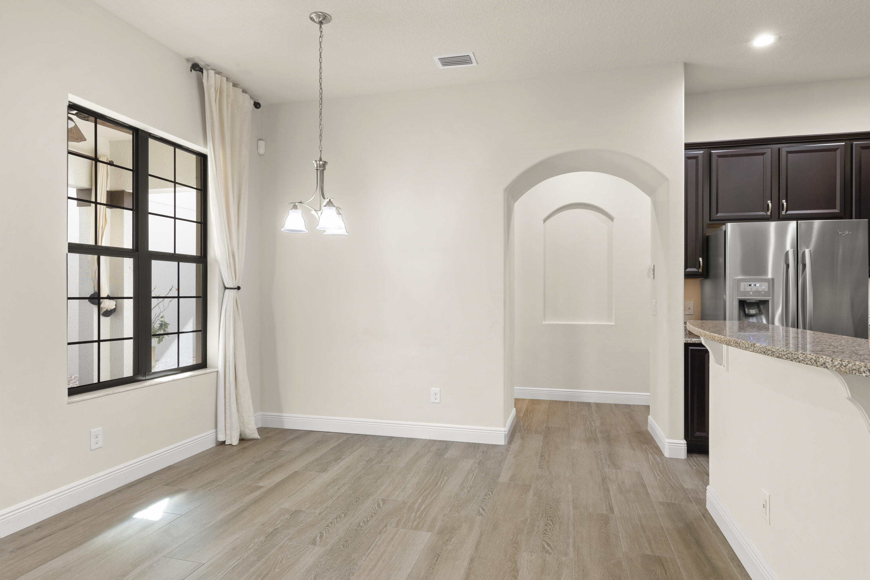 7065 Primavera Lane Melbourne, FL 32940 - Photo 8 of 40 a view of empty room with a window and wooden floor