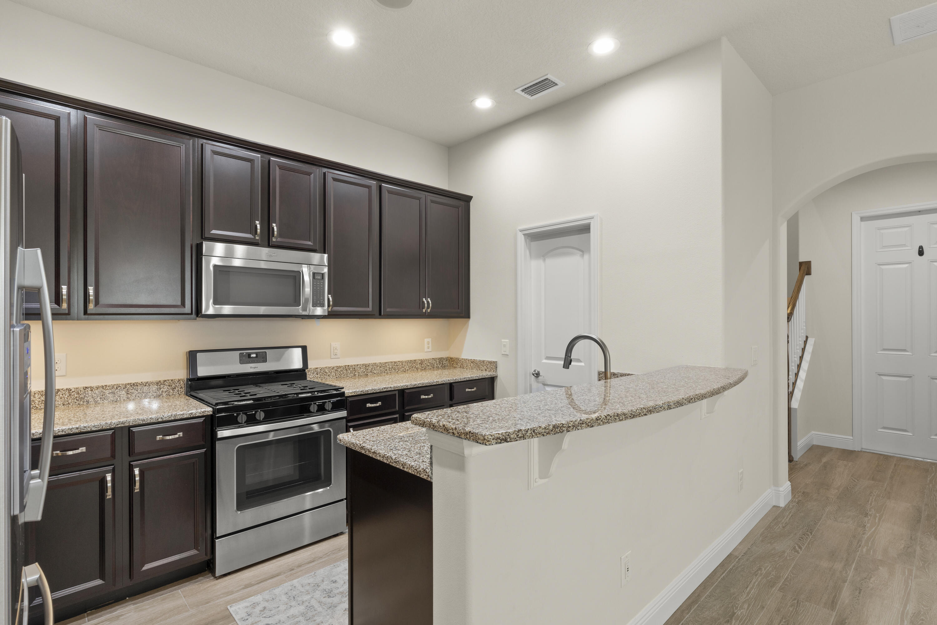 7065 Primavera Lane Melbourne, FL 32940 - Photo 9 of 40 a kitchen with granite countertop stainless steel appliances and wooden cabinets