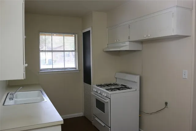 a kitchen that has a sink and a stove in it