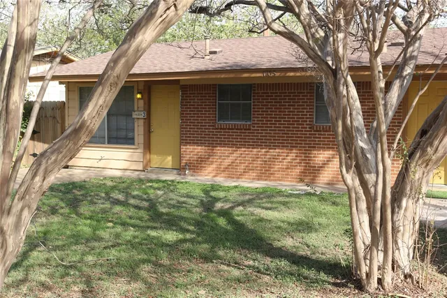 a view of a small house with a large tree