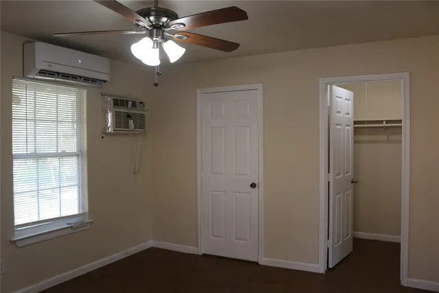 a view of empty room with window and ceiling fan