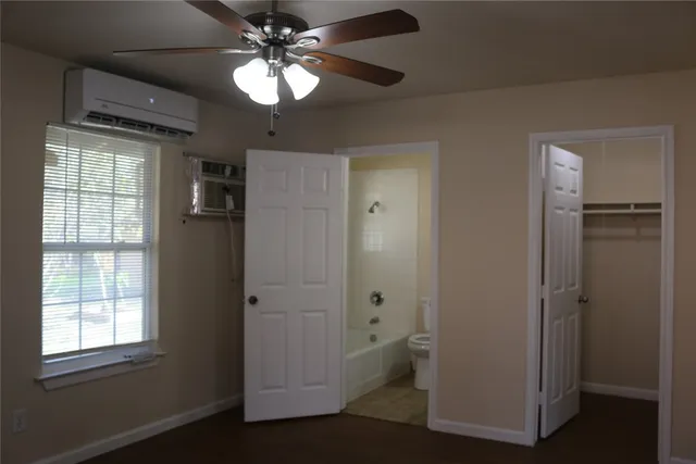 an empty room with closet and a chandelier fan