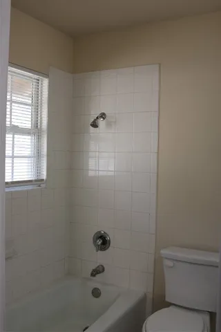 a bathroom with a shower a toilet and a sink