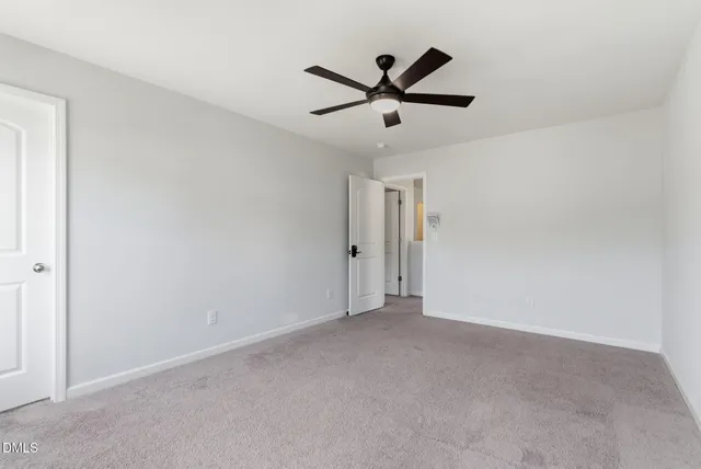a view of a big room with wooden floor closet and windows in it