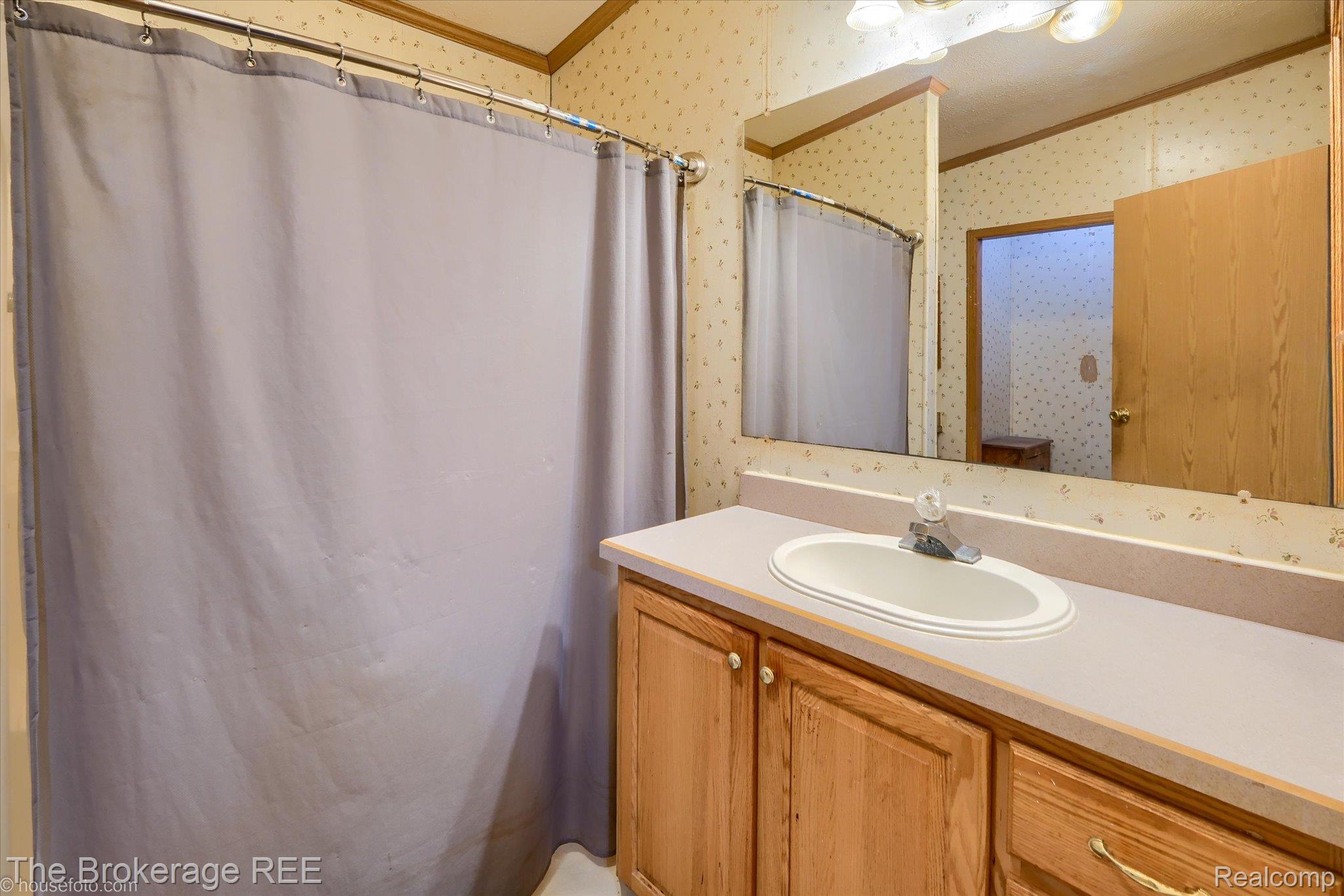 8247 North Center Road Mount Morris, MI 48458 - Photo 34 of 46 Full bath with wallpapered walls, vanity, a shower with shower curtain, and ornamental molding