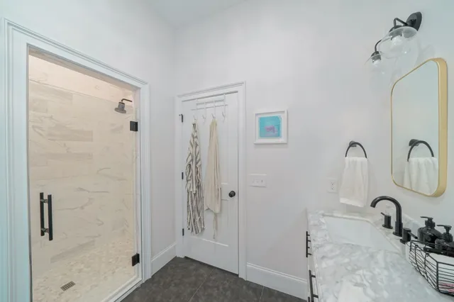 a en suite bathroom with a granite countertop sink and a mirror