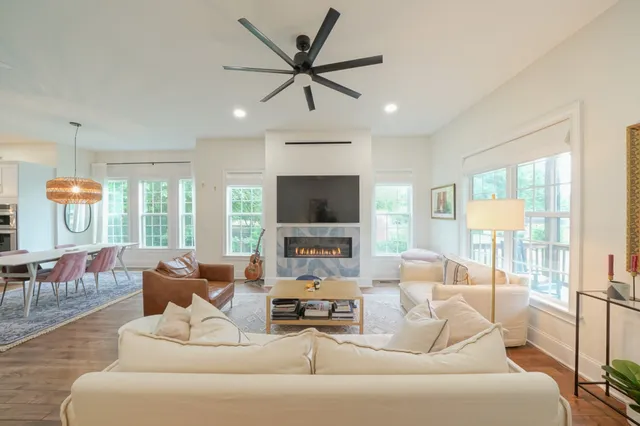 a living room with furniture ceiling fan and a flat screen tv