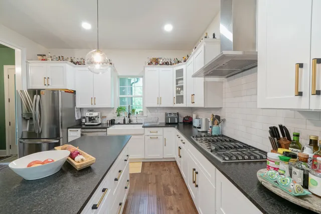 a kitchen with stainless steel appliances granite countertop a stove and a refrigerator
