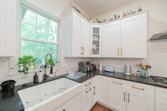 a kitchen with a white sink and cabinets