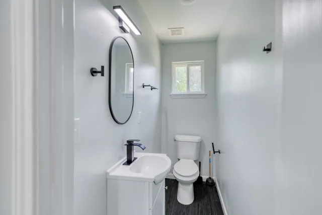 a bathroom with a toilet sink and mirror