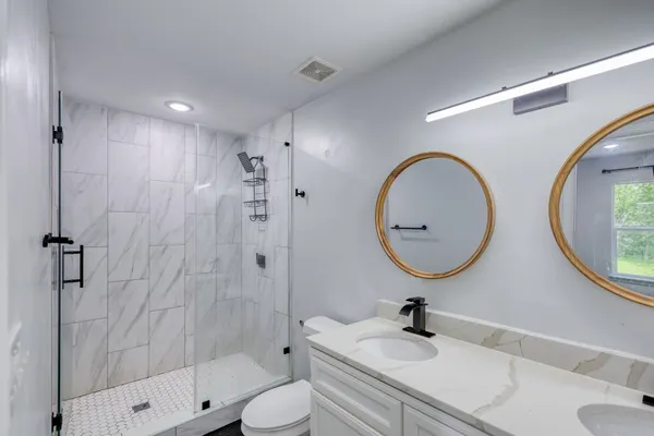 a bathroom with a sink a toilet and a mirror