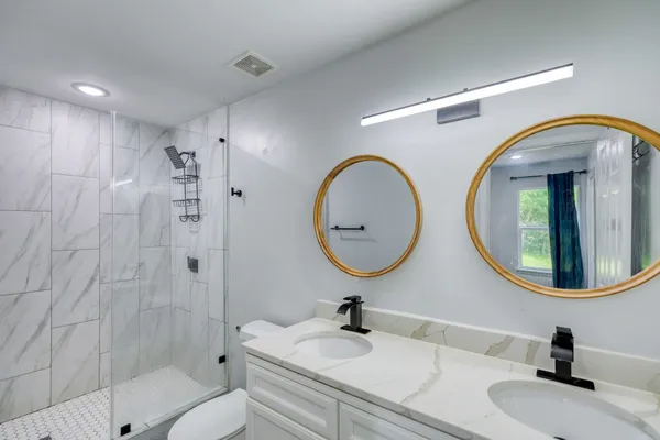 a bathroom with a sink a toilet and a mirror