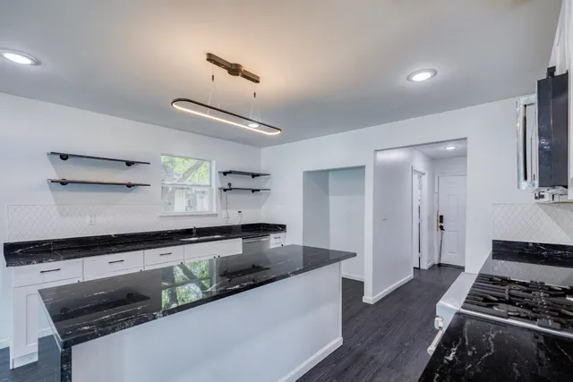 a kitchen with stainless steel appliances a stove a sink and cabinets