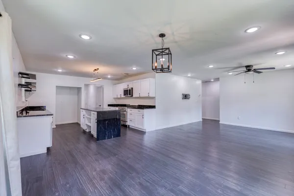a view of kitchen with refrigerator microwave and wooden floor