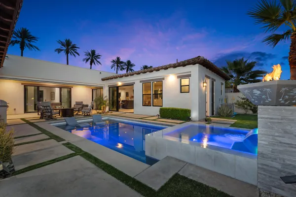 a view of a house with swimming pool and sitting area
