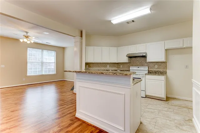 a kitchen with granite countertop white cabinets and white appliances