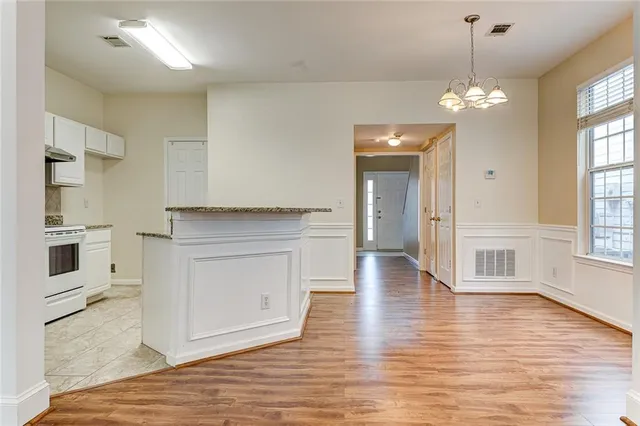 a view of a kitchen with a dishwasher a kitchen island hardwood floor and a ceiling fan