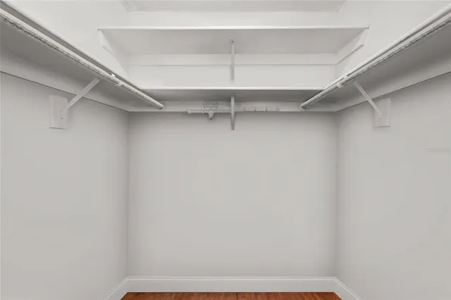 a view of walk in closet with empty racks