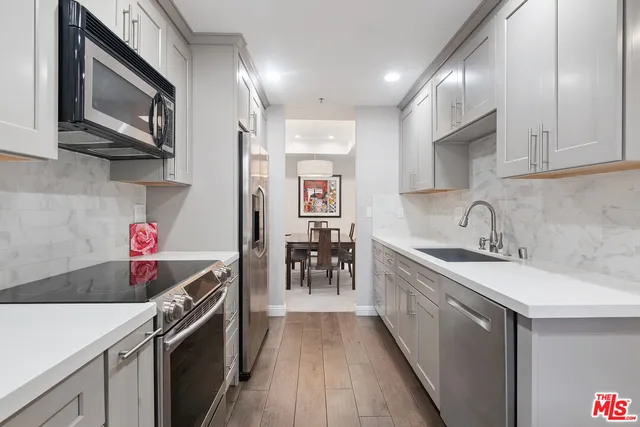 a kitchen with stainless steel appliances granite countertop a sink and cabinets