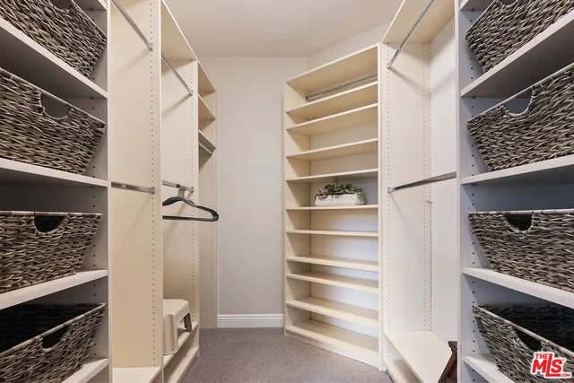 a view of walk in closet with empty racks
